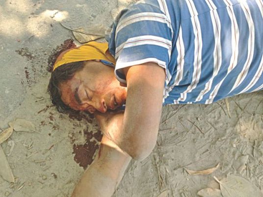 Sub-inspector Abdus Sabur of the Special Branch of police bleeds on ground after Jamaat-Shibir activists smashed his head with bricks at Chirirbandar of Dinajpur yesterday. Photo: Star
